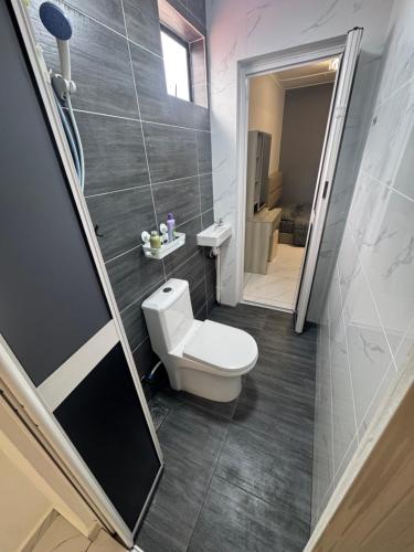 a small bathroom with a toilet and a shower at Sweet Homestay Bahau in Bahau
