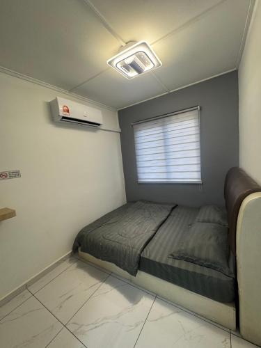 a small bedroom with a bed and a window at Sweet Homestay Bahau in Bahau