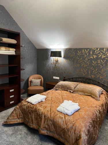 a bedroom with a bed with two towels on it at Шале Вершина in Palyanytsya