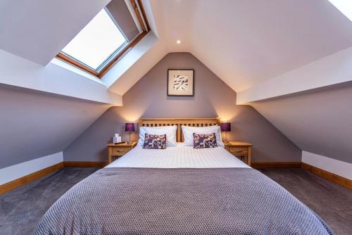 a attic bedroom with a bed and a window at Finest Retreats - Cedar Tree Cottage in Clocaenog