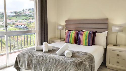 a bedroom with a bed with a large window at The Gray House in Bicas