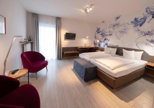ein Hotelzimmer mit einem Bett und einem Stuhl in der Unterkunft Flair Hotel zum Storchen in Bad Windsheim