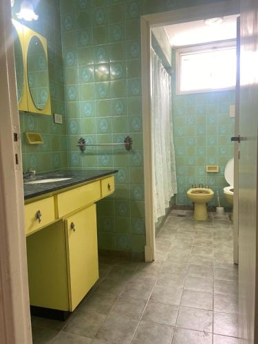 a bathroom with a yellow sink and a toilet at Casa en Miramar in Miramar