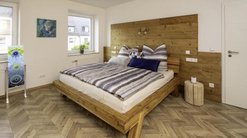 a bedroom with a large bed with a wooden headboard at Die Blaue Pause 42 in Weißenstadt