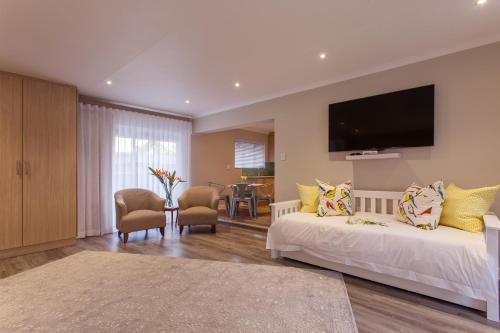 a living room with two beds and a flat screen tv at The Aviary in Pretoria