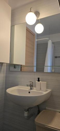 a bathroom with a white sink and a mirror at Thalassa in Perdika