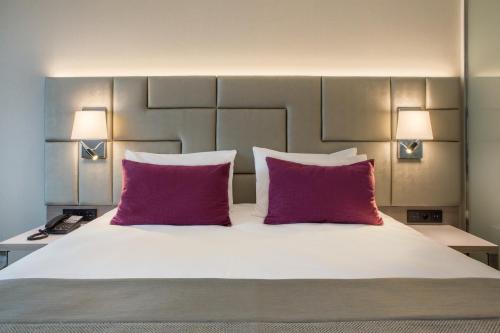 a bedroom with a bed with two purple pillows at Mercure Krakow Stare Miasto in Kraków
