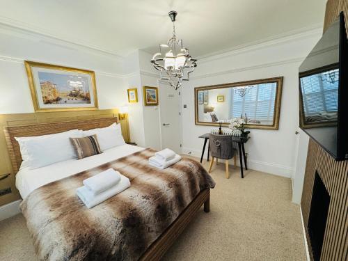 a bedroom with a large bed and a chandelier at Luxury 2 Bed Designer Apartment & Garden in Bexleyheath