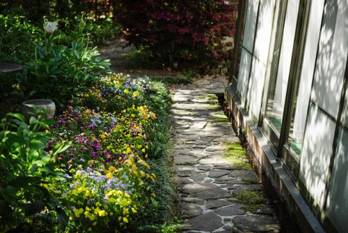 a garden path with flowers next to a building at Pension Yufuin in Yufuin