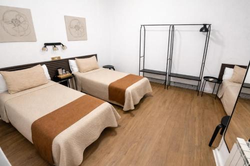 a hotel room with two beds and a mirror at Hostal Prada in Madrid