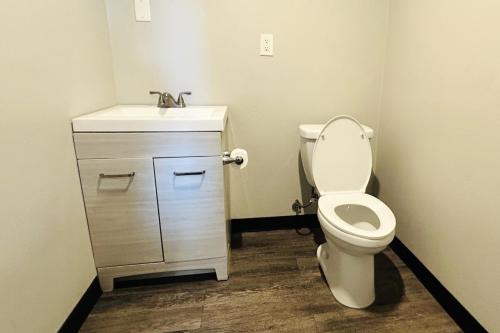 a bathroom with a toilet and a sink at The Queen B Motel, Detroit-Warren in Warren