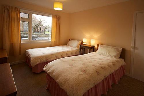 a hotel room with two beds and a window at Correay Cottage in Salen