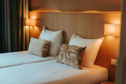 a hotel room with a bed with two pillows at Donia Huys in Oost-Vlieland
