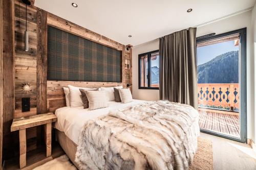a bedroom with a large bed and a large window at Apartment Danton, Châtel - by EMERALD STAY in Châtel