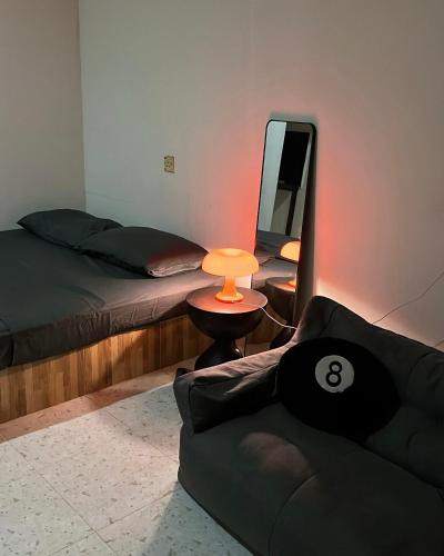 a bedroom with a bed and a mirror and a couch at Temin Roomstay in Pulau Langkawi
