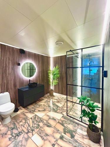 a bathroom with a toilet and plants in it at Casa Troll in Tromsø