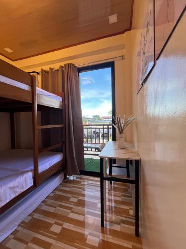 a room with bunk beds and a table and a window at Ambungan Homestay - Siargao in General Luna