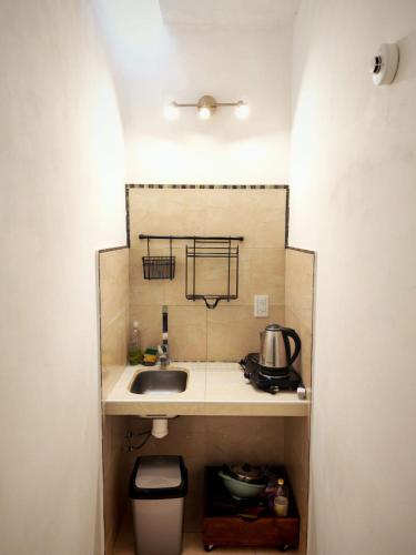 a small kitchen with a sink and a trash can at Aisha Alojamiento in Salta
