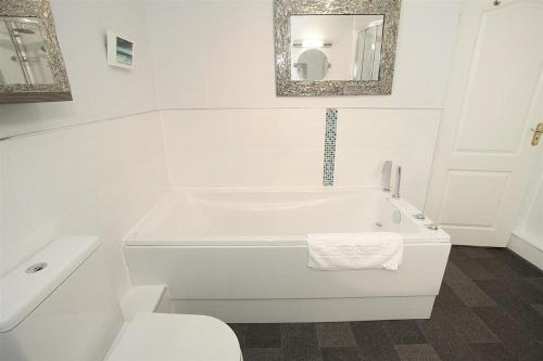 a white bathroom with a tub and a toilet at 1 Bed in Langland oc-hh147 in Newton