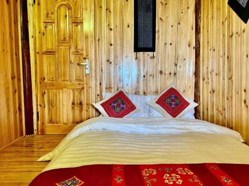 a bedroom with a bed with two pillows on it at H'mong Village Homestay in Sapa