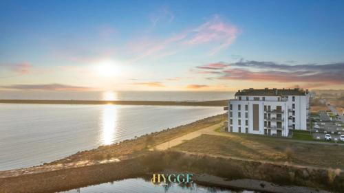 a building on the beach next to the water at Penthouse Hygge Meerblick - Olpenitz in Olpenitzdorf