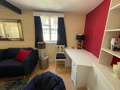 a living room with a couch and a desk at Central Woodstock Townhouse nr Blenheim Palace in Woodstock