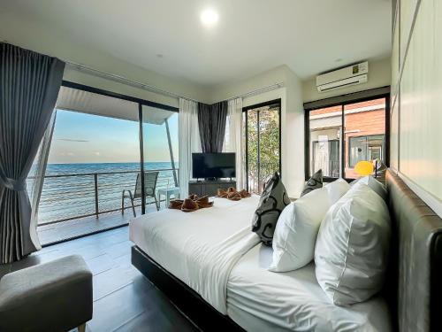 a bedroom with a large bed with a view of the ocean at Leamsai Beach Resort in Suratthani