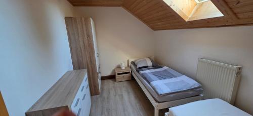 a small bedroom with a bed and a skylight at Haus Annemarie in Goldkronach