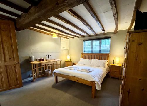 a bedroom with a bed in a room with a ceiling at The Pear Tree in Hook Norton