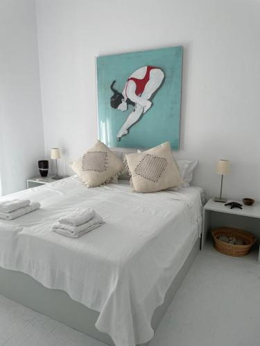 a white bed with two towels on top of it at The White House 1 in Andros