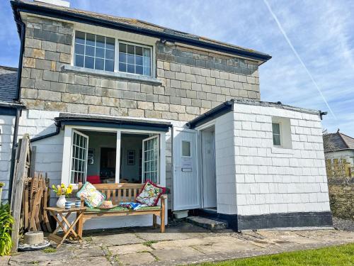 a small house with a door and a bench outside at Coastguard Cottage in Downderry