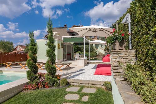 a backyard with a pool and an umbrella at Il Nido 2&2 in Staggiano