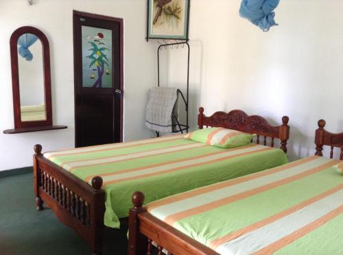 a bedroom with two beds and a mirror at Lagoon Inn in Hambantota