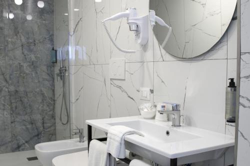 a white bathroom with a sink and a shower at Hotel Stabia in Castellammare di Stabia