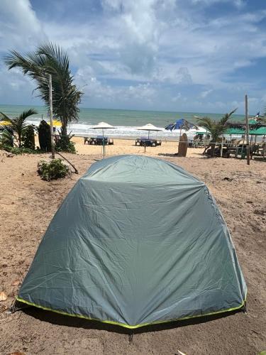 a green tent on the beach near the ocean at Eco Camping Surf in Pipa