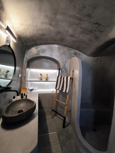 a bathroom with a sink and a mirror at Imarkellis Santorini Cave House with yard in Pyrgos