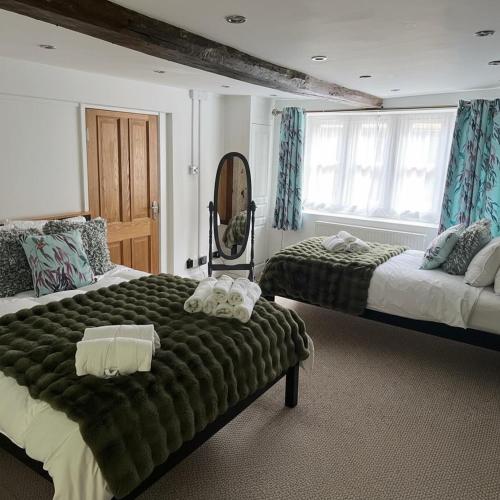 a bedroom with two beds and a large window at The Cotswold Wellhouse in Tetbury