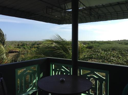 a table on a balcony with a view of the jungle at Lagoon Inn in Hambantota