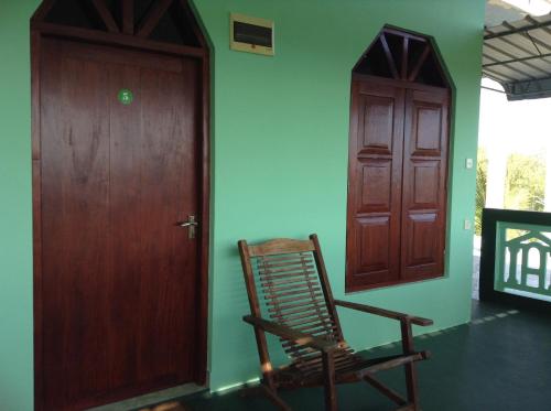 a rocking chair in a room next to a door at Lagoon Inn in Hambantota