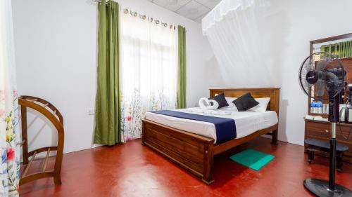 a bedroom with a bed with a fan and a window at Paddy Breeze Homestay in Sigiriya