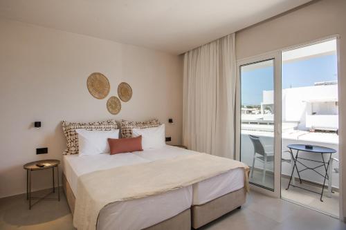 a bedroom with a large bed and a balcony at Pado Living in Faliraki