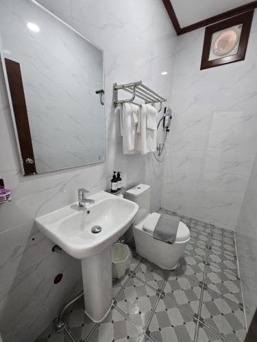 a white bathroom with a sink and a toilet at Villa ThreeD Xaydara in Luang Prabang