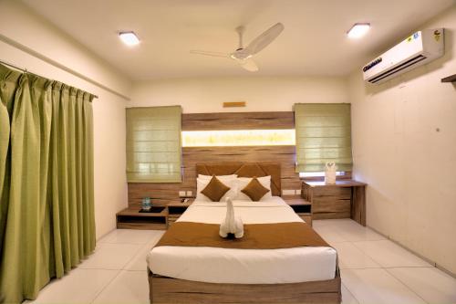 a bedroom with a bed and a green curtain at VRR Astoria Hotel & Convention Center in Bangalore