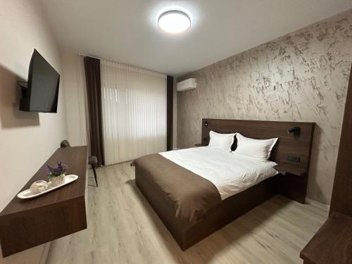 a bedroom with a large bed and a television at Алтъна Калофер in Kalofer
