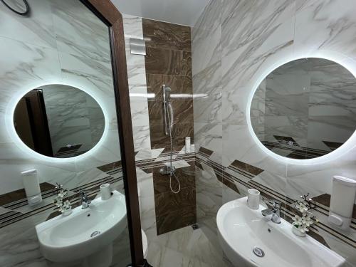 a bathroom with two sinks and two mirrors at Алтъна Калофер in Kalofer