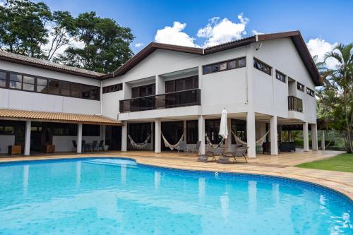 a building with a swimming pool in front of a building at Pousada Costa Rielli in Águas de Lindoia