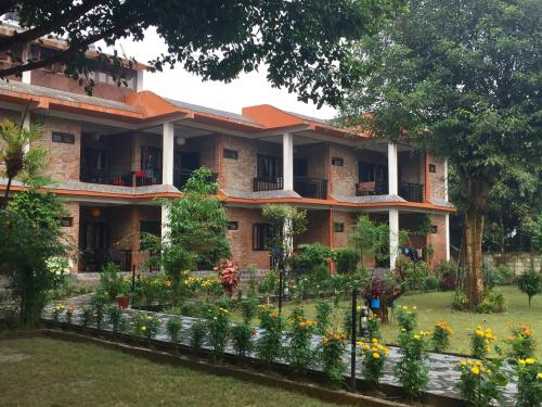 a building with a garden in front of it at Chautari Garden Resort in Sauraha