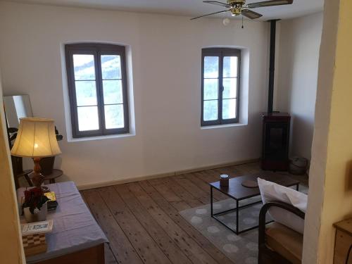 a living room with two windows and a couch at Casa vacanze Feltre in Feltre