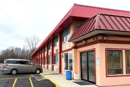 a van parked in a parking lot in front of a building at Red Carpet Inn & Suites Lima -Listing Partner in Lima