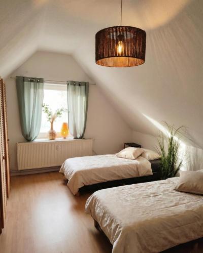 a bedroom with two beds and a window at Ferienwohnungen Auetal in Kucksdorf